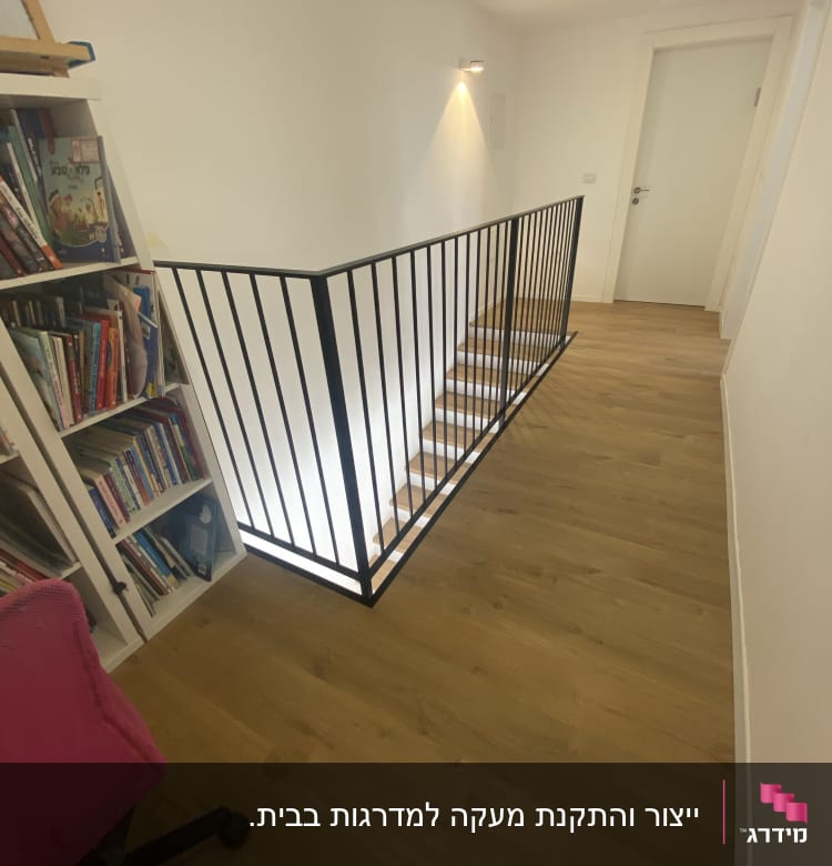 מעקה מתכת שחור לאורך גרם מדרגות עץ